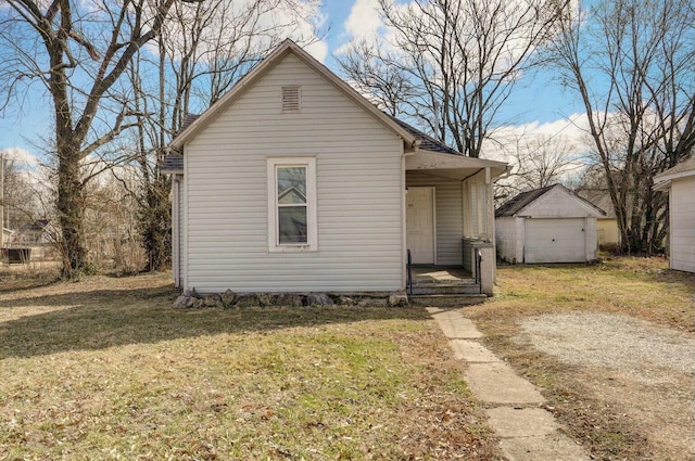 bungalow-style home with an outbuilding and a front yard