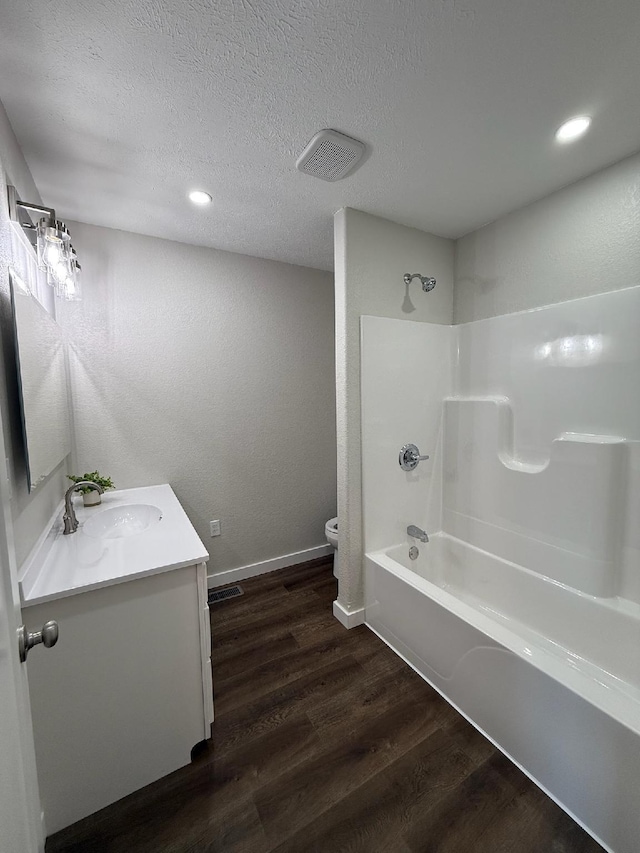 full bathroom featuring toilet, bathtub / shower combination, visible vents, wood finished floors, and vanity