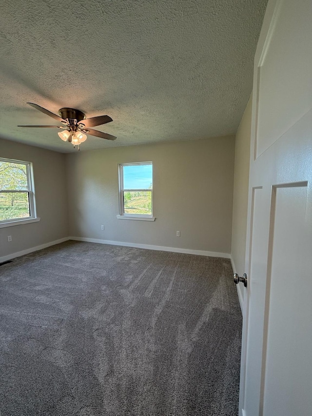 unfurnished room with baseboards, a ceiling fan, a textured ceiling, and carpet