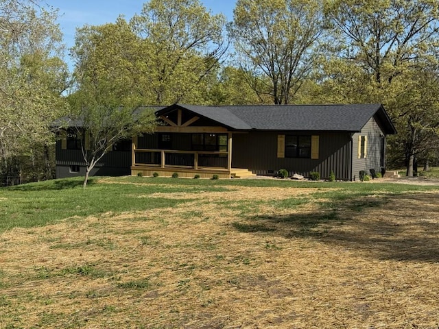 back of house with a lawn and covered porch