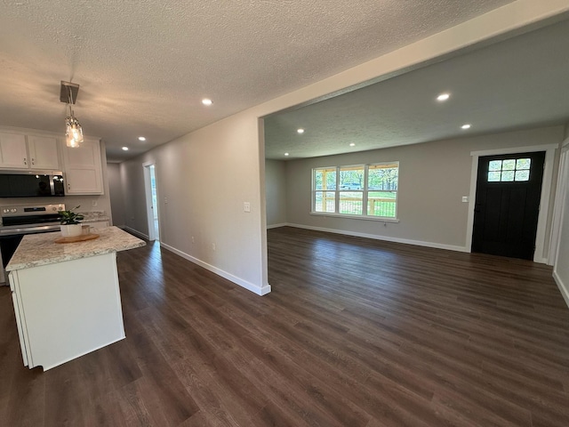 kitchen featuring open floor plan, appliances with stainless steel finishes, a textured ceiling, and recessed lighting