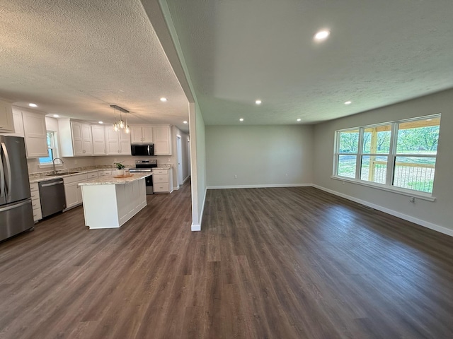 kitchen featuring recessed lighting, a sink, a kitchen island, appliances with stainless steel finishes, and open floor plan