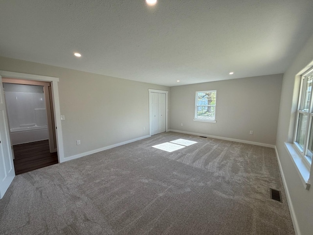 unfurnished bedroom with baseboards, visible vents, carpet, and recessed lighting