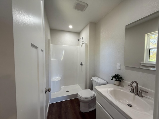full bath with wood finished floors, walk in shower, visible vents, and toilet