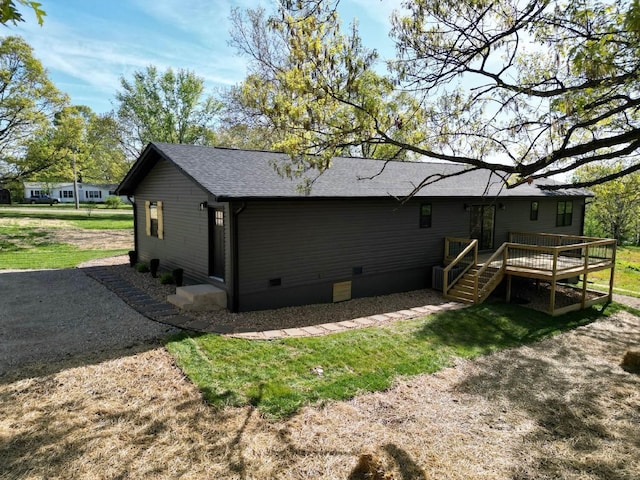 rear view of house featuring a yard, roof with shingles, crawl space, and a deck