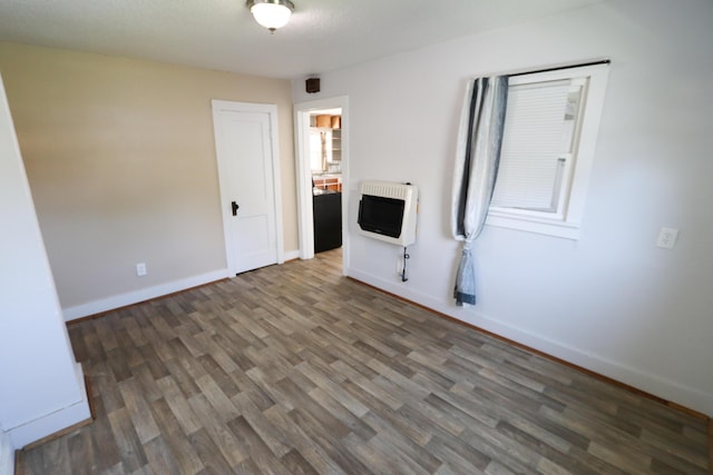 419 E Olive St, Bolivar, MO 65613 - empty room featuring baseboards, heating unit, and wood finished floors