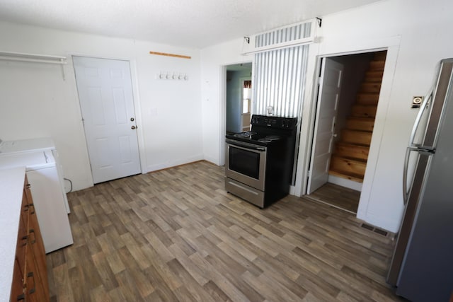 419 E Olive St, Bolivar, MO 65613 - kitchen with stainless steel appliances, wood finished floors, visible vents, and washer and dryer