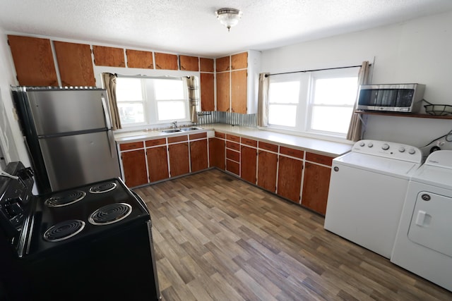 419 E Olive St, Bolivar, MO 65613 - kitchen with washer and dryer, brown cabinets, black range with electric stovetop, and freestanding refrigerator