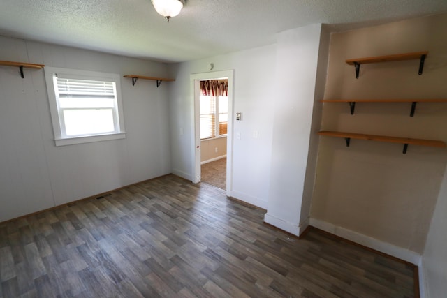 419 E Olive St, Bolivar, MO 65613 - unfurnished bedroom with baseboards, wood finished floors, and a textured ceiling