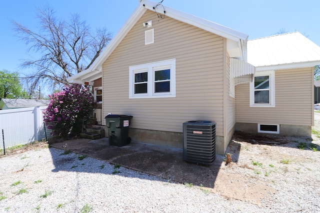 419 E Olive St, Bolivar, MO 65613 - rear view of property featuring cooling unit, metal roof, and fence