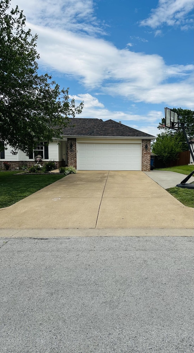 4723 W Portland St, Springfield, MO 65802 - view of front facade with concrete driveway, brick siding, a garage, and a front lawn