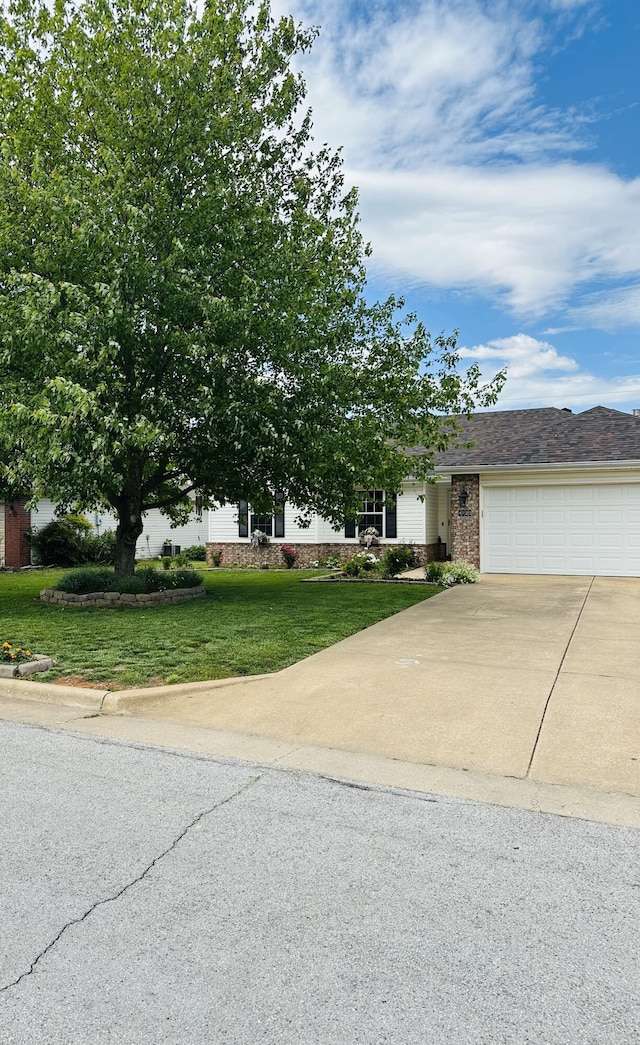 4723 W Portland St, Springfield, MO 65802 - view of front of house with driveway, a garage, a front yard, and brick siding