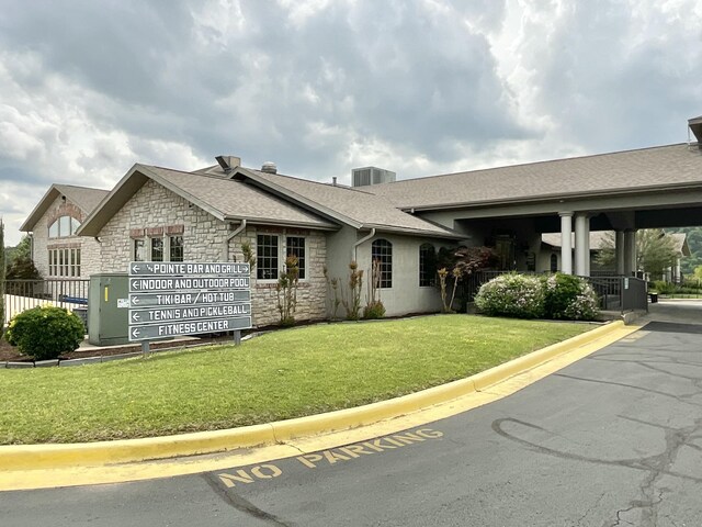 187 Clubhouse Dr Unit 23, Branson, MO 65616 - view of front of house with stone siding, a shingled roof, a front lawn, and central air condition unit