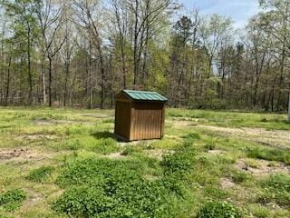 view of shed with a forest view