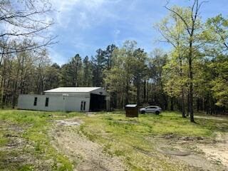 view of yard featuring an outbuilding and a wooded view