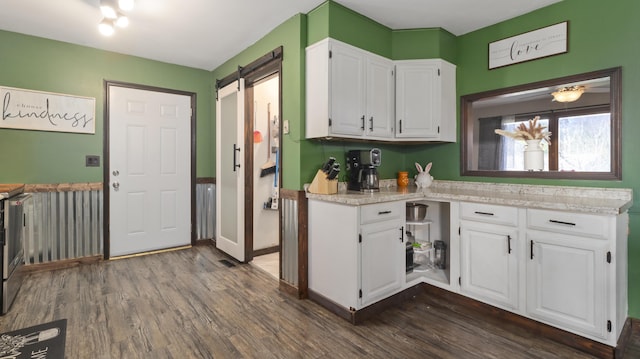 402 Lake, Mountain Grove, MO 65711 - kitchen featuring a barn door, light countertops, white cabinets, baseboards, and dark wood-type flooring