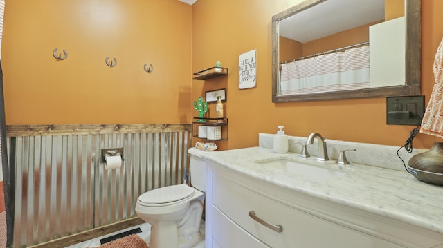 402 Lake, Mountain Grove, MO 65711 - bathroom featuring visible vents, toilet, vanity, and wainscoting