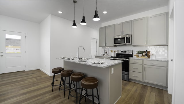 4074 E Ashwood Ct, Brookline, MO 65619 - kitchen featuring stainless steel appliances, a sink, a center island with sink, gray cabinets, and dark wood-type flooring