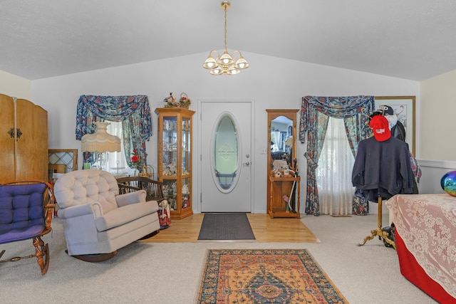 carpeted foyer entrance with a chandelier and vaulted ceiling
