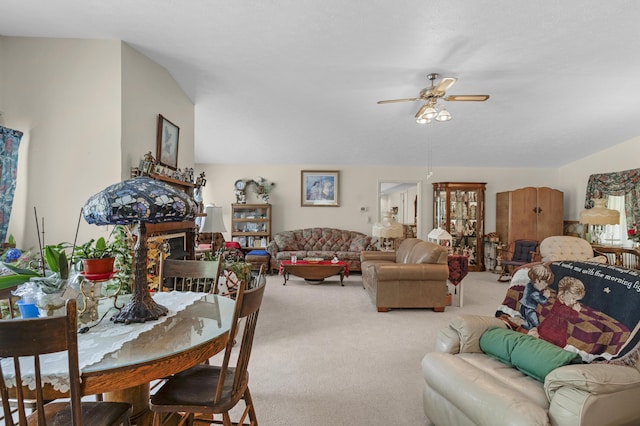 living room featuring carpet, ceiling fan, and a fireplace
