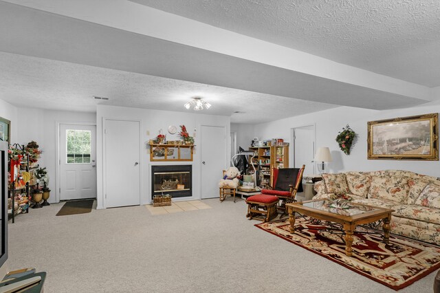 carpeted living area with a fireplace with flush hearth and a textured ceiling