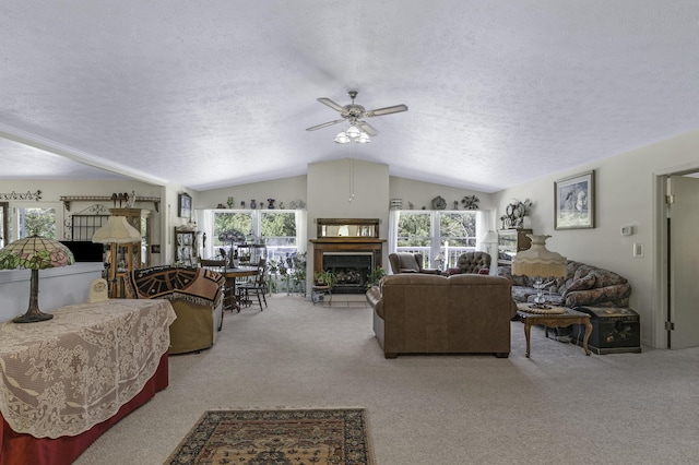 335 State Highway 265, Hollister, MO 65672 - living area with vaulted ceiling, a textured ceiling, light carpet, a ceiling fan, and a fireplace with raised hearth