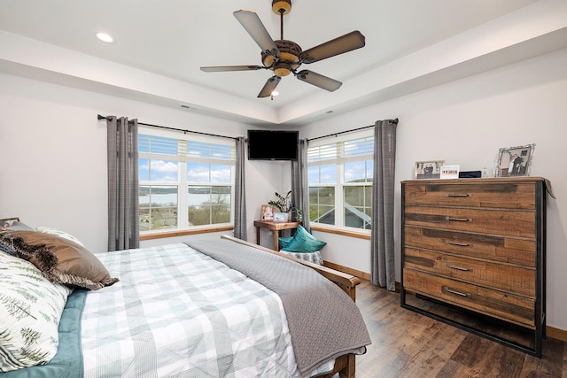 bedroom featuring baseboards, recessed lighting, wood finished floors, ceiling fan, and a raised ceiling