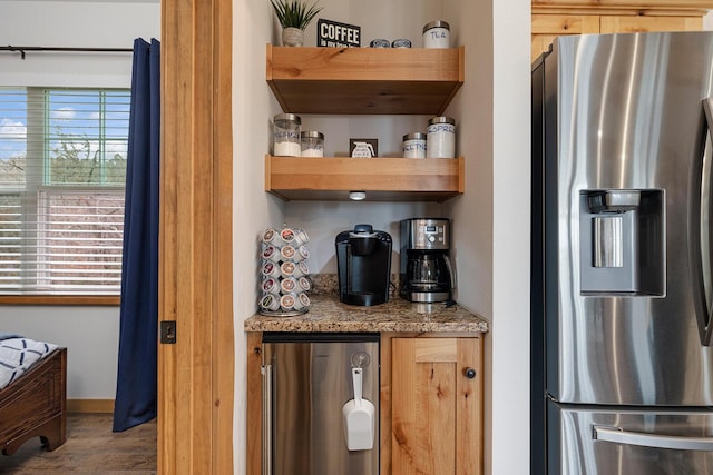interior space featuring refrigerator, light stone counters, wood finished floors, stainless steel fridge with ice dispenser, and baseboards