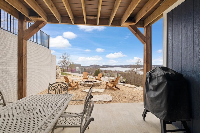 view of patio / terrace featuring a fire pit, outdoor dining area, a grill, and a mountain view