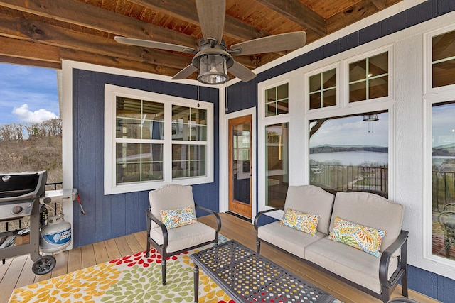 sunroom / solarium with a ceiling fan, an outdoor hangout area, wooden ceiling, wood-type flooring, and beam ceiling