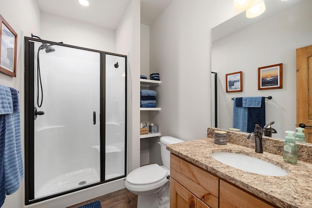 full bath with a shower stall, toilet, vanity, and wood finished floors