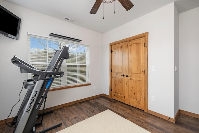 workout area featuring baseboards, a ceiling fan, wood finished floors, and visible vents