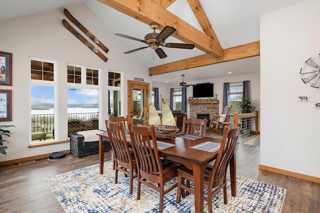 dining area with ceiling fan, baseboards, wood finished floors, and a fireplace