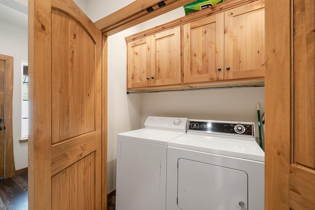 laundry room with dark wood-style floors, washer and clothes dryer, and cabinet space