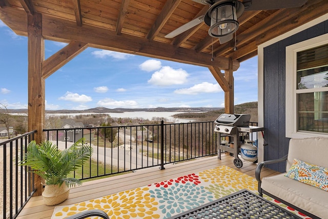 balcony with a ceiling fan, area for grilling, and a water view