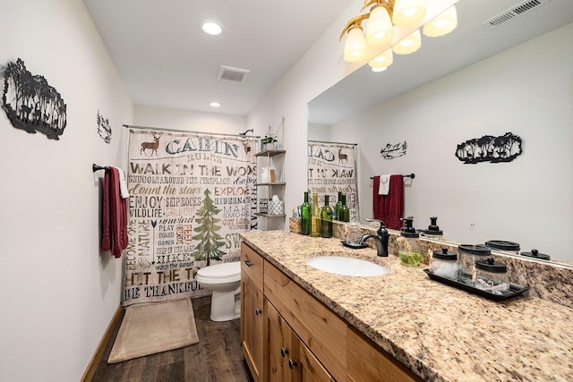 full bathroom with wood finished floors, visible vents, toilet, and vanity
