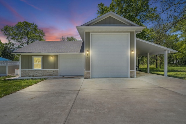 view of front of home with board and batten siding, roof with shingles, stone siding, and concrete driveway
