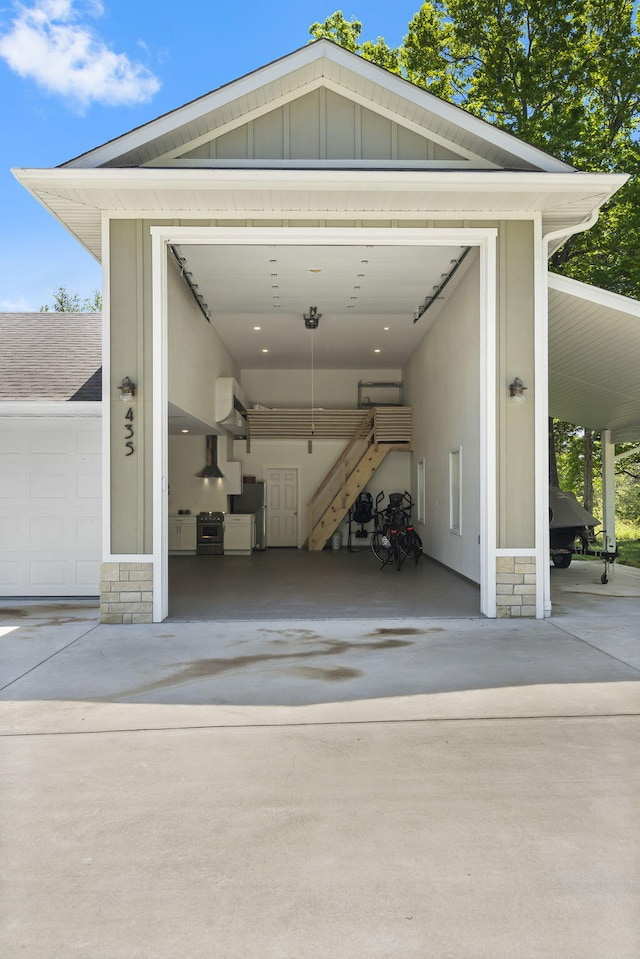 garage with freestanding refrigerator and concrete driveway