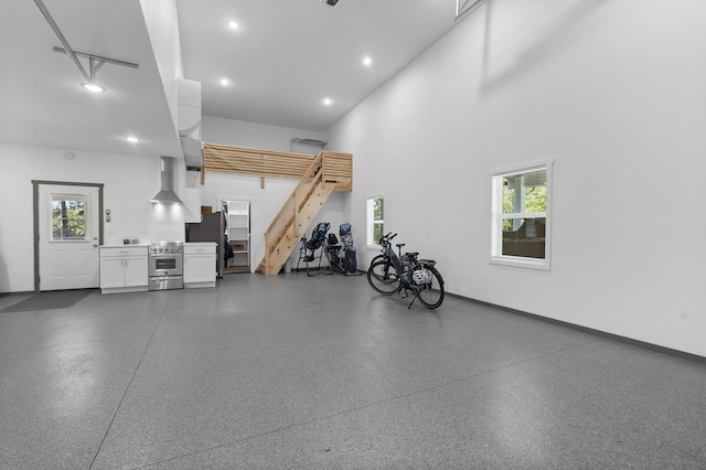garage with baseboards, freestanding refrigerator, and recessed lighting