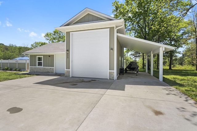 exterior space with board and batten siding, stone siding, a front lawn, and concrete driveway