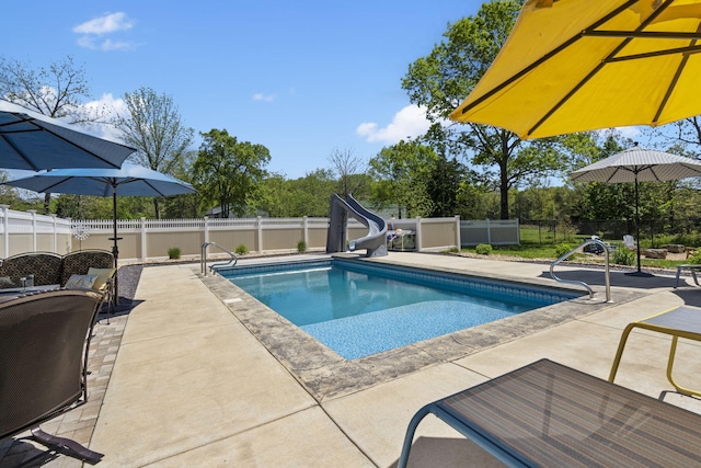 view of swimming pool featuring a fenced in pool, a water slide, a fenced backyard, and a patio
