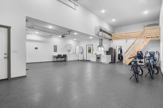 garage with recessed lighting, electric panel, and freestanding refrigerator
