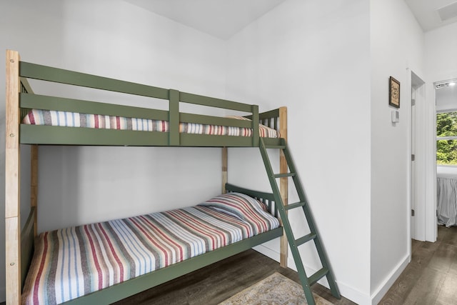 bedroom with visible vents, baseboards, and wood finished floors