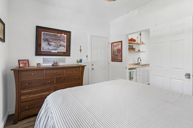 bedroom with baseboards, dark wood-style floors, indoor wet bar, and a sink