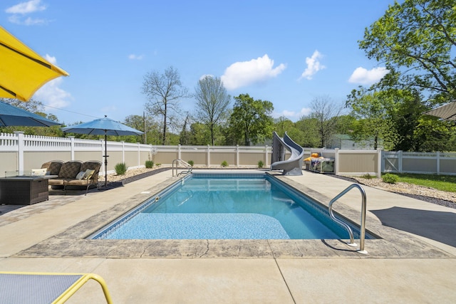 view of swimming pool with a fenced backyard, a fenced in pool, a patio, an outdoor hangout area, and a water slide