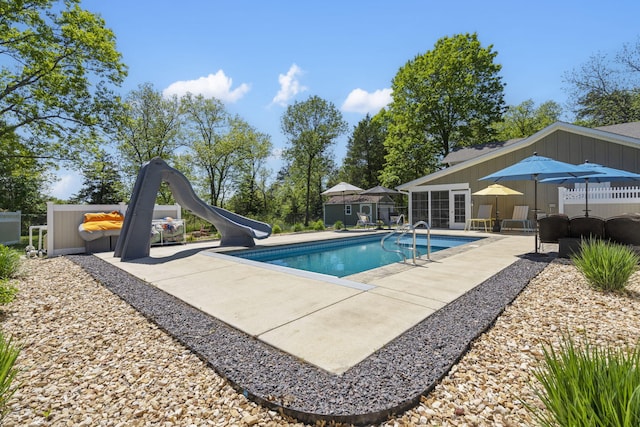 pool with a water slide and a patio area