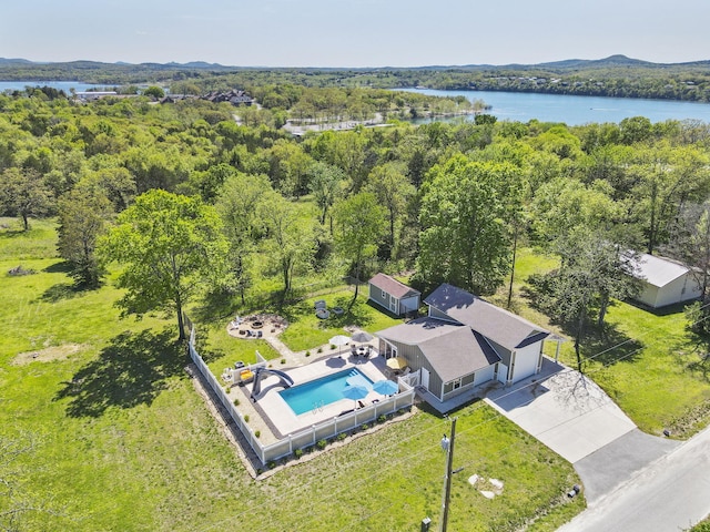 birds eye view of property featuring a forest view and a water view