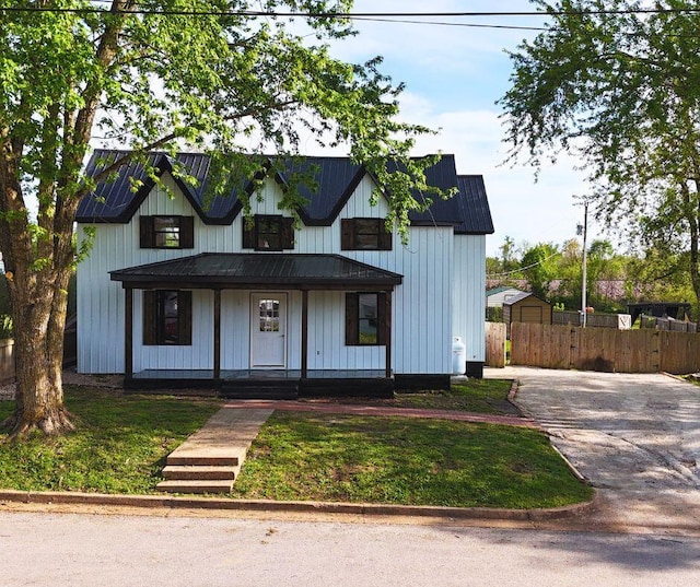 310 W N St, Mountain Grove, MO 65711 - modern farmhouse with a front lawn, driveway, covered porch, fence, and metal roof