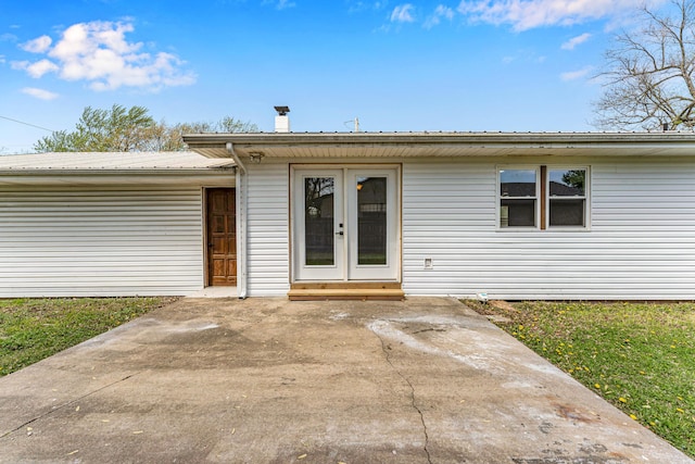 ranch-style home featuring metal roof and french doors