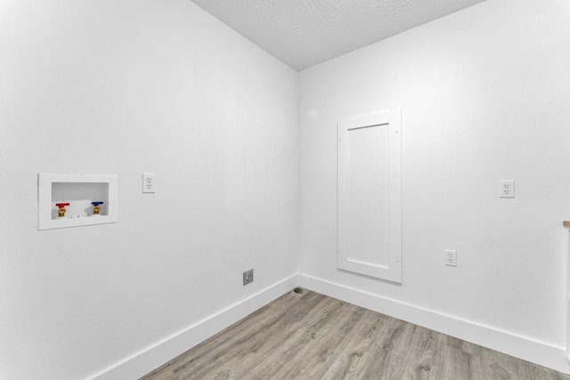 clothes washing area with laundry area, washer hookup, baseboards, and light wood-style floors
